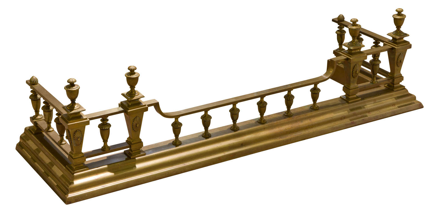 An ornate Victorian brass fender